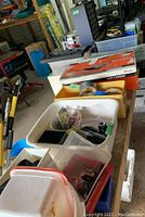 Photo showing boxes, plastic organizers with fasteners, and hand tools arranged on a table.