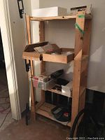 Wooden shelving unit with various boxes and tools stored