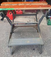Front view of the Workmate foldable workbench with wooden clamping surface and metal frame showing some rust.