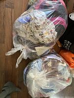 Two large clear plastic bags filled with assorted fabric pieces showing various colorful patterns and sizes