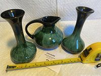 Three-piece set consisting of two vases and one jug with measuring tape showing size.