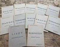 Layout of all 12 softcover books in the set shown on wooden surface, titles visible.
