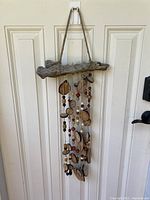 Full view of the Arbutus wood chip and bead windchime hanging on a door, showing overall length and structure.