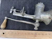 Side view of vintage LF & O New Britain meat grinder with wooden handle and ruler for scale, showing length around 16 inches.