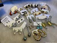 Overview of assorted pierced earrings placed on table showing multiple pairs with varied designs and styles.