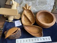Photo of wooden bowls including round bowls, divided star design bowl, long leaf-shaped bowl, and lidded container with bark.