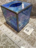 Square stained glass tissue box cover with ocean blue shimmer and metal frame, shown with measuring ruler and auction tag.