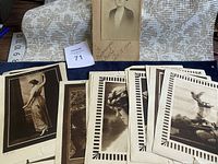 Collection of vintage sepia tone photographs arranged on fabric background with ruler for size reference. Photos include portraits of men and women in period attire.