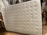 Photo of double mattress showing quilted white top and circular patterns