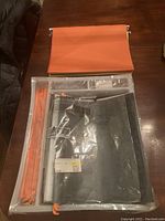 Full set of Ikea Summera filing system unassembled, showing folded hanging files and rails in plastic bag on wooden table.