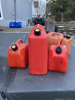 Front view of all four jerry cans showing varying heights and cap colors.