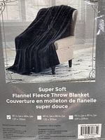 Image of black flannel fleece throw blanket displayed on chair and packaging label showing product details and size 50x60 inches.