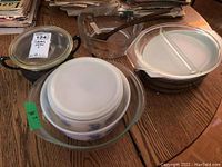 Photo showing six Corning Ware bowls stacked, glass divided serving dish, and clear Pyrex glass mixing bowl.