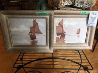 Two framed pastel paintings of sailing ships placed side by side on a metal rack. Both frames are textured gold-tone. One smaller (7x9.5 inches), one larger (11.5x13.5 inches).