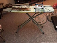 Full view of the standard folding ironing board with the smaller sleeve board and Black & Decker iron placed on top.