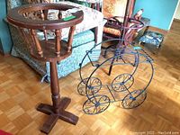 Photo showing both plant stands, wooden with spindle perimeter and metal wire cart style