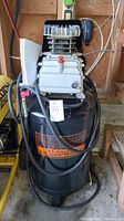 Front view of the entire black vertical air compressor with Central Pneumatic branding, showing the tank and motor head assembly with attached hoses.