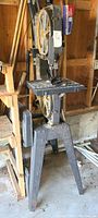 Full view of the 15-inch band saw mounted on a metal stand inside a workshop.