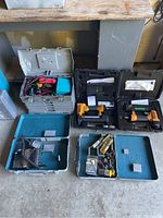 Photo showing two Bostitch tools in their cases, metal and plastic toolboxes containing various tools and electrical parts.
