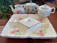 Photo of three vintage floral teapots and a divided ceramic serving dish with pink flowers