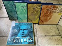 Five boxes of Beethoven Bicentennial Collection with one separate LP titled 'The Nine Symphonies of Beethoven' shown on a tile floor, illustrating the lot contents and condition.