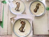 Three Hummel collector plates from 1971 and 1972 showing angels, cardboard box, and packing material.