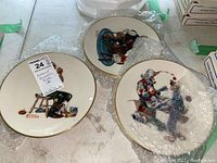 Six Hummel collector plates shown partially wrapped in bubble wrap, displaying three plates clearly with vintage style illustrations by Norman Rockwell.