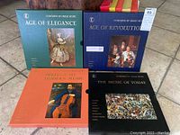 Four boxed LP record collections titled Age of Elegance, Age of Revolution, The Music of Today, and Prelude to Modern Music, arranged on floor tiles.