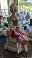 Close-up of Cinderella porcelain figurine in pink dress, showing seated pose and detailed painting.