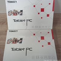 Two Tokecy Tablet PC boxes stacked, showing front packaging with brand, model, and features icons.