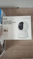 Laxihub P2 Full HD 1080P Indoor Pan Tilt Wi-Fi Smart Camera box showing product photo and app interface