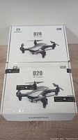 Two sealed and boxed DEERC D20 HD Camera drones stacked vertically showing product image and branding.