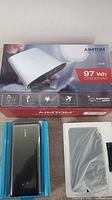 Photo of AIMTOM S268 power station box and two power banks in plastic packaging on table.