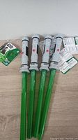 Four Star Wars Apprentice Lightsabers with green blades and gray handles, placed side by side with original packaging tags attached.