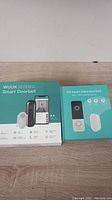 Two smart video doorbells side by side in factory packaging: WUUK and HD Smart Video Doorbell