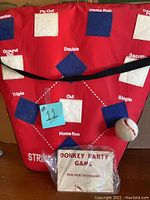 Fabric baseball toss game board showing various labeled targets and plush baseball