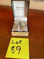 Photo showing two Geneva Extra Superior watches in a beige and black presentation box with a lot number 89 note in front.