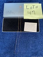 Sarah Coventry box with delicate thin gold chain necklace laid out inside, along with a note indicating lot number.