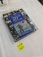 The closed book with the dust jacket titled 'The 20th Century: A Chronicle in Pictures' showing historical photo collage and astronaut image.