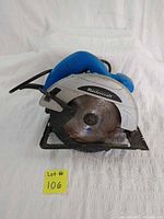 Front view of blue and silver Mastercraft circular saw with worn blade and black base plate.