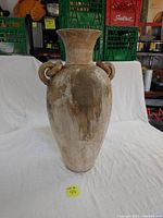Front view of large decorative clay vase showing full shape, flared neck, and one loop handle.