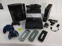 Overall view of two PS3 consoles, two Xbox 360 consoles, Kinect sensor, controllers, HDD shells and cables