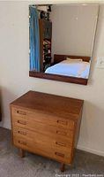 Front view of dresser and mirror against wall