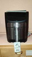 Front view of Gourmia air fryer, showing black body and stainless steel door with handle and control panel.