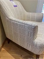 Side view of the upholstered side chair showing armrest and fabric pattern.