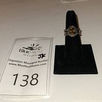 Front view of Silpada topaz trio ring set on black display stand with auction tag.