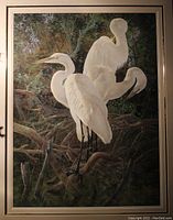 Photo of the framed wildlife art print showing three white egrets in a forest setting with green foliage background.