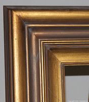 Close-up of the gold wood frame corner showing the texture and gold finish.