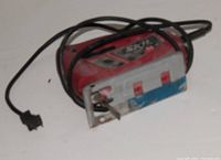 Photo of a red and silver SKIL jig saw with power cord, showing the tool from an angled side view.
