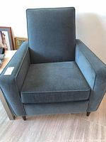 Front angled view of the recliner chair showing seat cushion, armrests and legs.